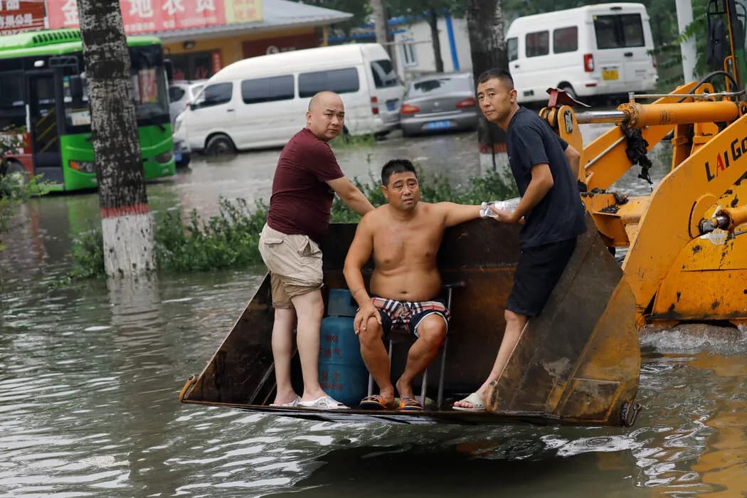 涿州一辆铲车上的人们。 Tingshu Wang/Reuters