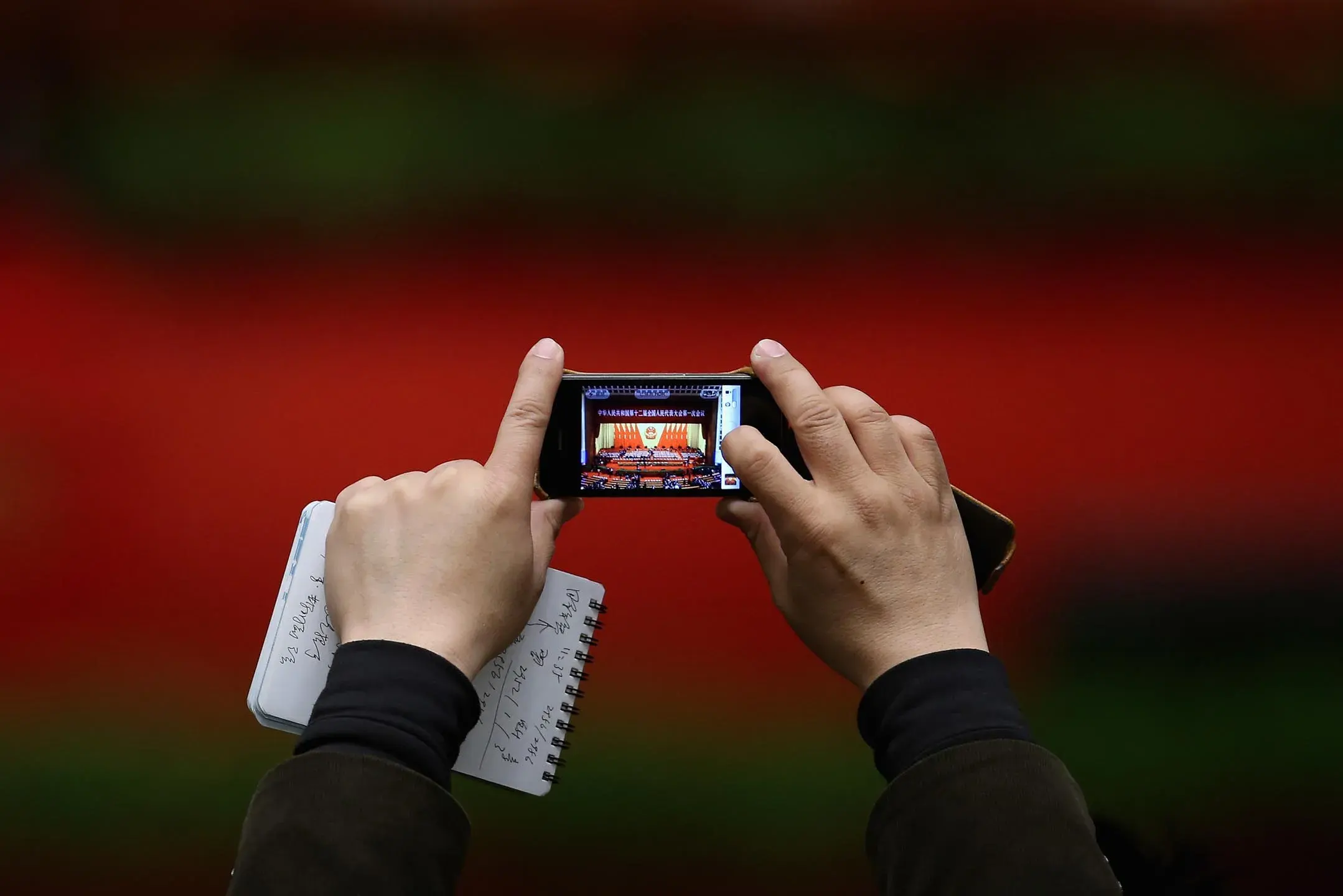 2013 年 3 月 14 日，中国北京，一名记者在全国人民代表大会上用手机拍照。摄：Feng Li/Getty Images